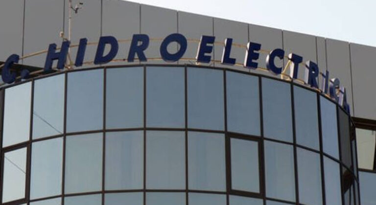 Curved glass facade of a modern building with a blue Hydroelectric sign along the top edge.